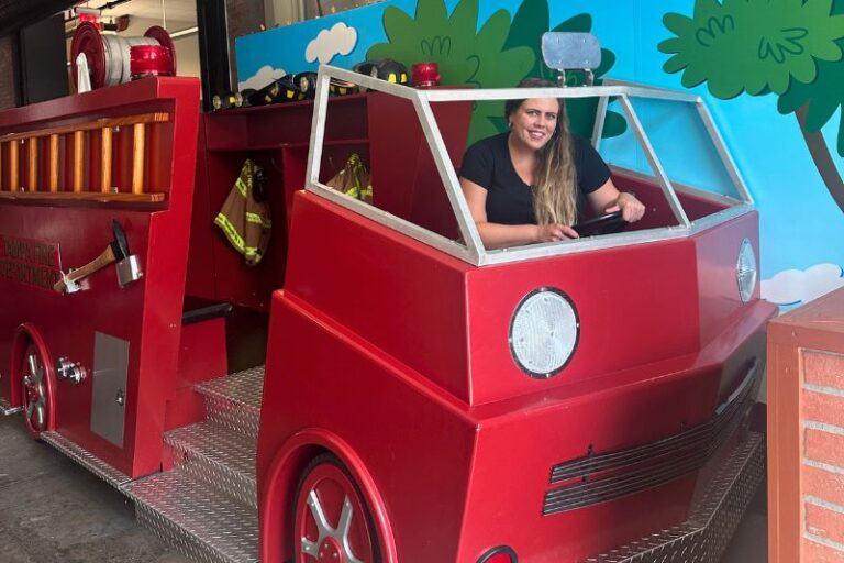 young woman poses for photo in Interactive Components at the Tampa Bay Fire Fighters Museum -