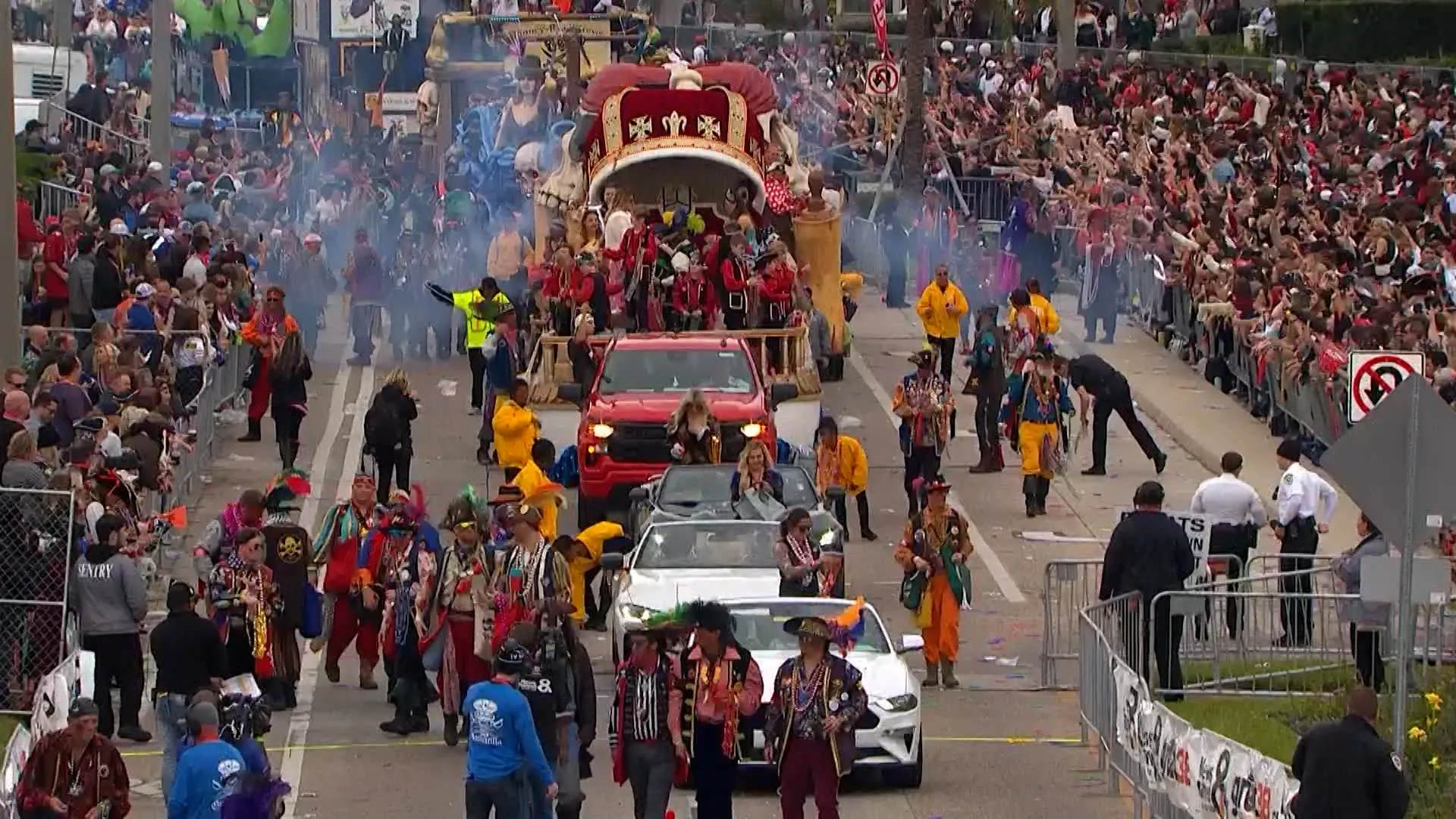 Colorful Gasparilla Parade with floats, performers, and crowds lining the street in Tampa.