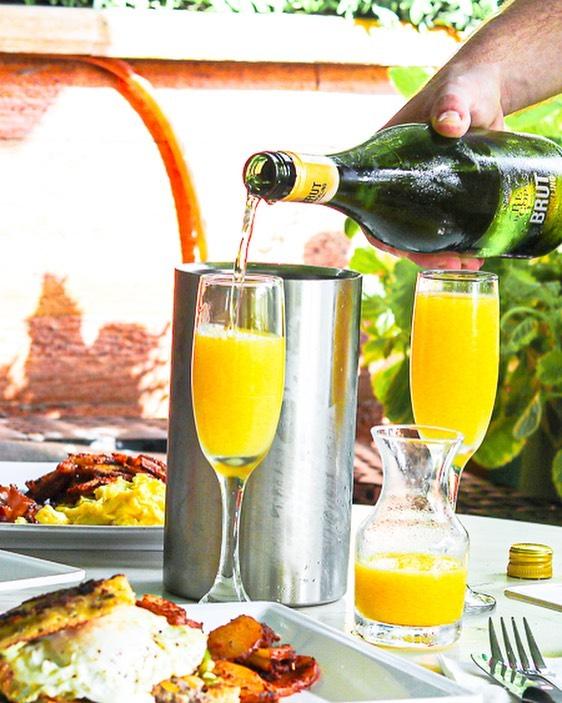 A bottle of champage and with mimosas during bottomless brunch @waterandfloursoho