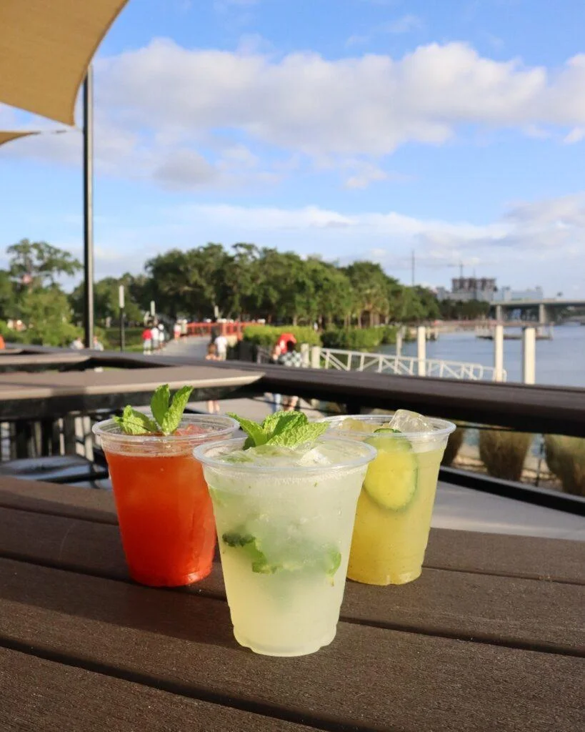 three cocktails sitting on a table near the water Waterfront Dining at Stone's Throw