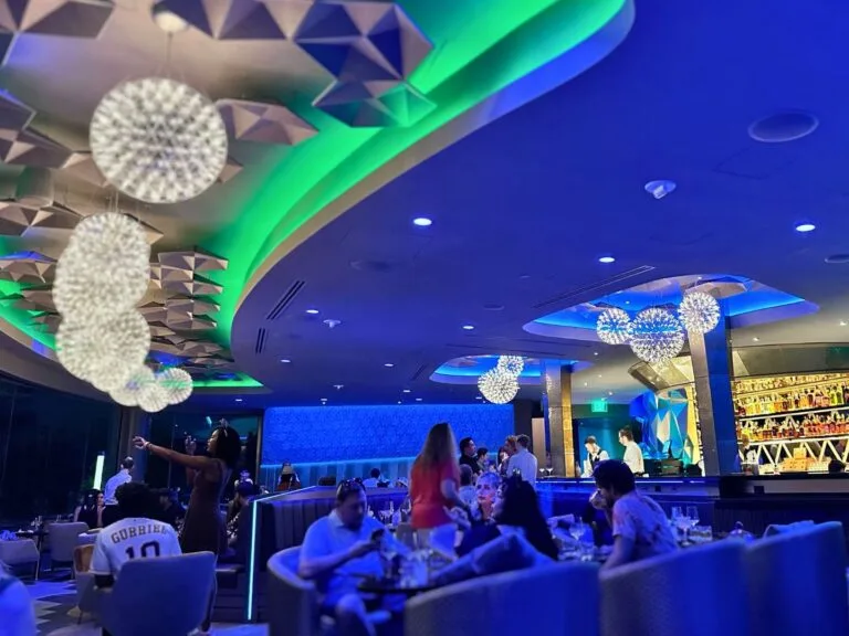GEO-82 Adults Only Lounge at EPCOT dining area with view of EPCOT evening lighting cool hues - image by Dani Meyering compress