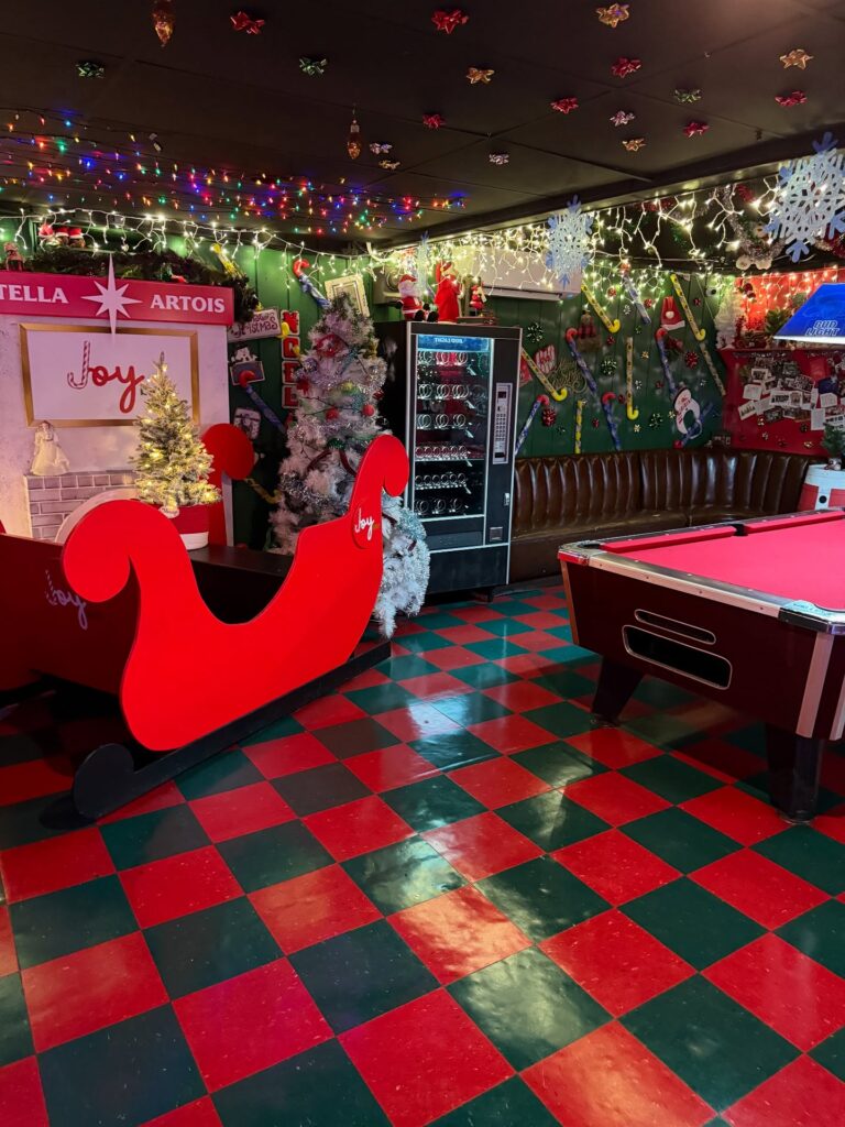 christmas themed dive bar with sleigh and green red tile floor