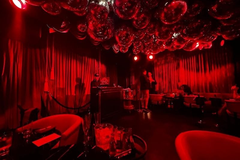 The EDITION Red Room After Hours inside featuring red, velvet, and disco balls.