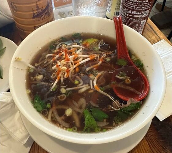 The Glass Noodle's Steak Pho with noodles, broth, steak, bean sprouts, cilantro, and onions.