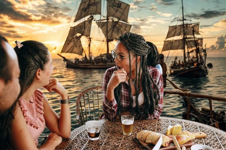 Gasparilla Tampa Bay Brunches three adults at table for brunch with pirate ships in background - image created by Dani Meyering with canva pro images